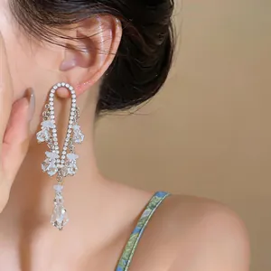Detalle de pendientes de borla con pedrería en estilo francés