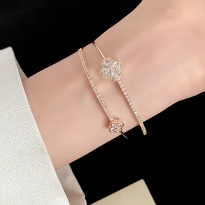 Close-up of elegant double-layer gold bracelet with sparkling cubic zirconia flowers