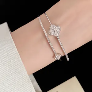 Detail view of a silver 18k gold plated double bracelet with zircon flower and tennis chain