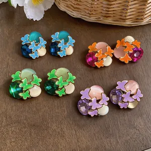 Detailed macro view of four pairs of colorful butterfly stud earrings with rhinestones