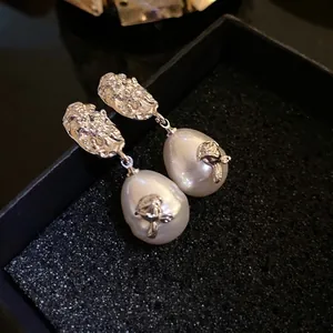 French vintage silver-tone stud earrings featuring textured flower design and pearl drops