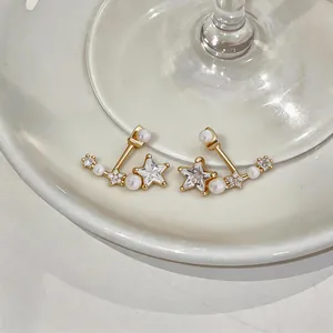 Dettaglio ravvicinato di eleganti orecchini a stella con perle e zirconi