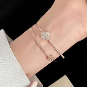 Close-up of 18k gold plated double-layer bracelet with zircon flower detail on wrist