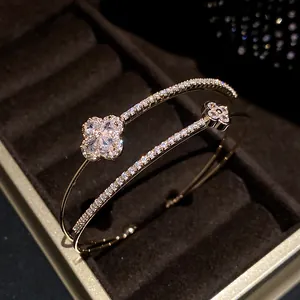 Detail view of 18k gold plated double-layer bracelet with sparkling zircon clover charms