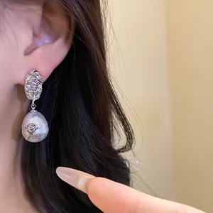 Close-up detail of French vintage silver textured flower pearl earrings with rose pattern.