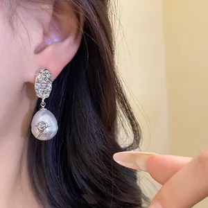 Close-up of French vintage crumpled flower earrings with large teardrop pearl details