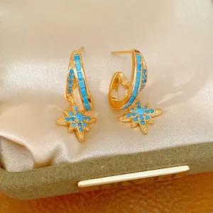 Elegant gold star dangle hoop earrings with turquoise zircon stones in a jewelry box