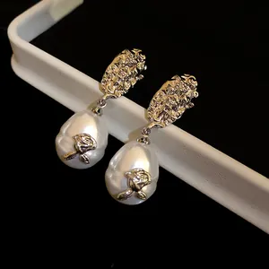Macro view of vintage French style wrinkled silver flower with pearl drop stud earrings