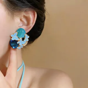 Close-up of elegant blue enamel butterfly stud earrings with sparkling gems
