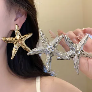 Detailansicht von metallischen Seestern-Ohrringen in Gold und Silber mit Knitteroptik