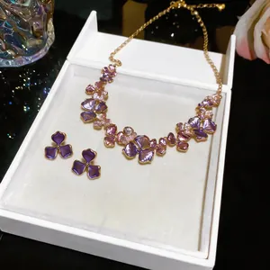 Macro view of French style floral necklace and earring jewelry set with purple metallic finish