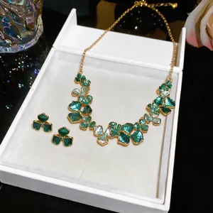 Close-up of green painted flower necklace and earrings set in a white gift box