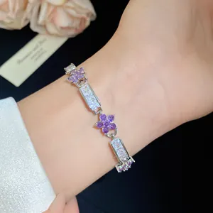 Détail macro d'un élégant bracelet argenté avec fleurs en zircon violet et pierres