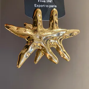 Detailansicht der glänzenden goldenen Seestern-Ohrringe mit Texturoberfläche