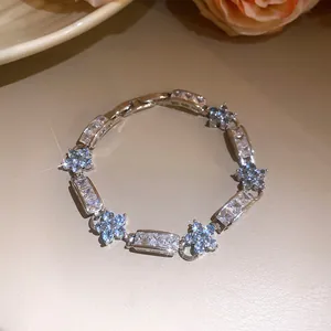 Vue rapprochée d'un bracelet fleur en zircon scintillant avec des pierres bleu clair.