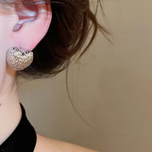 Detailed close-up of textured silver heart stud earring with elegant hammered finish