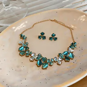 Close-up view of an elegant teal and white flower jewelry set including necklace and earrings.