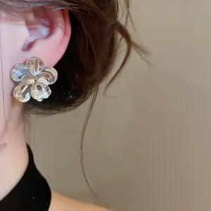 Macro view of an elegant silver metallic flower earring with a textured petal design