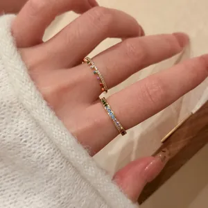 Close-up of 18k gold plated rainbow rings set with colorful stones on a hand