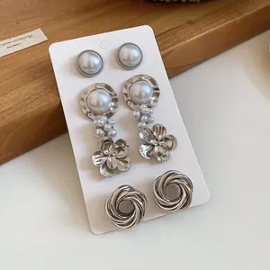 High-quality detail of vintage silver metal earring set with pearls on white display card