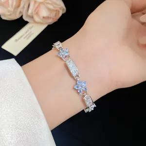 Vue détaillée d'un bracelet de fleurs en zircon sur un poignet avec des pierres bleu clair