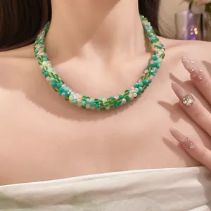 Vue détaillée d'un collier bohème à plusieurs rangs de perles de cristal vert porté