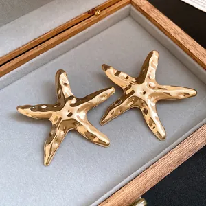 Detaillierte Makroansicht goldener Seestern-Ohrstecker mit gehämmerter Metallstruktur