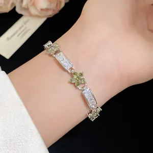 Détail d'un bracelet fleur en argent avec des pierres de zircon vert et incolore
