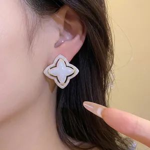 Vintage starburst flower stud earrings with pearlescent white inlay and gold trim