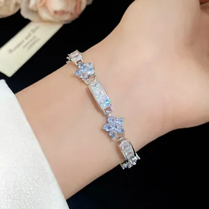 Bracelet élégant en argent avec des fleurs en zircone bleu clair au poignet d'un modèle