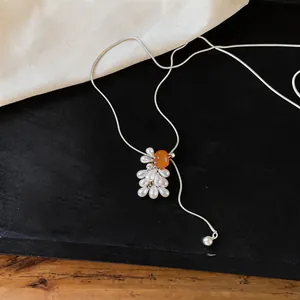 Close-up of a grape cluster necklace featuring a tiger eye stone and white pearls
