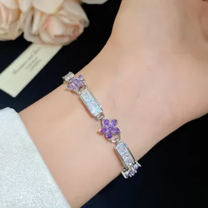 Gros plan d'un bracelet fleur en zircon violet avec des maillons en cristal clair.