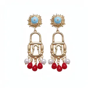 Vintage gold padlock earrings featuring a sun motif, pearls, and red teardrop tassels