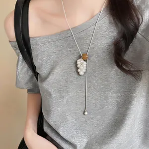 Detailed shot of tiger eye grape cluster pendant on a long silver-tone sweater chain
