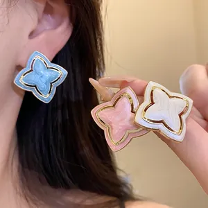 Detailed close-up of vintage star-shaped enamel stud earrings in blue, pink, and pearl white