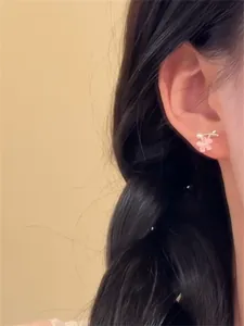 Gros plan d'une boucle d'oreille en pierre d'oeil de chat fleur de cerisier rose