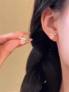 Gros plan détaillé montrant des boucles d'oreilles fleurs de cerisier en œil de chat