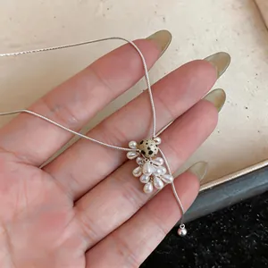 Detail view of a grape cluster pendant necklace with teardrop beads and a spotted accent bead.