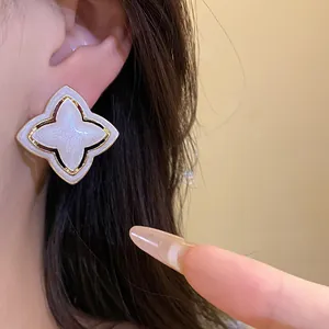 Detailed view of vintage star flower stud earrings with white pearlescent finish
