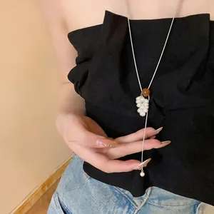 Close-up of elegant tiger eye and pearl grape cluster pendant on long silver chain
