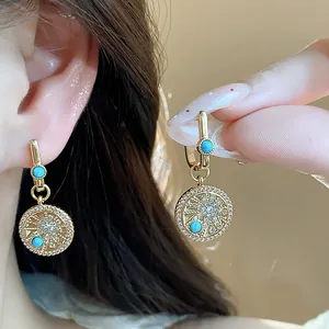 Détail macro des boucles d'oreilles vintage plaquées or 18 carats avec turquoise.