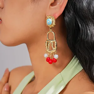 Detailed macro view of vintage gold padlock earrings with pearls and red bead tassels