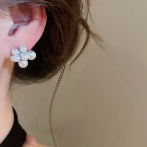 Close-up detail of cluster pearl stud earrings on ear for a retro luxury look