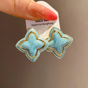 Detailed view of vintage light blue enamel star flower earrings with gold metallic trim