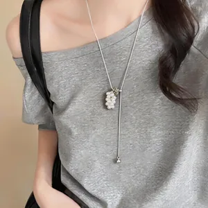 Close-up of elegant grape cluster pearl pendant on long silver sweater chain