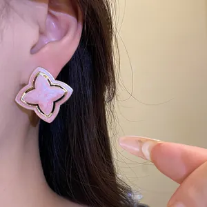 Macro view of a pink star flower stud earring featuring a vintage golden metallic trim