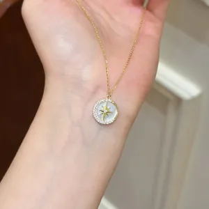 Detailed close-up of an elegant gold star and moon pendant necklace with sparkling zircons