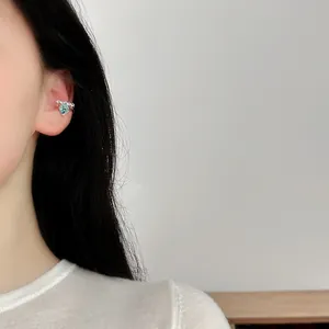 Close-up detail of a minimalist silver ear cuff with a blue square crystal stone