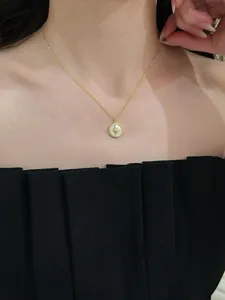 Close-up of a gold star and moon pendant necklace worn with an elegant black dress.