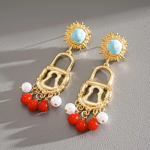 Detailed view of vintage gold lock earrings with colorful pearls and red tassels